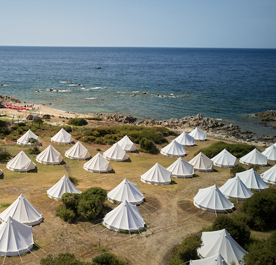 A beach area filled with large designer tents